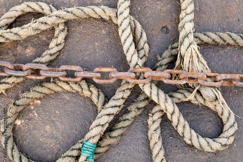 Old hemp mooring rope and rusty chain image