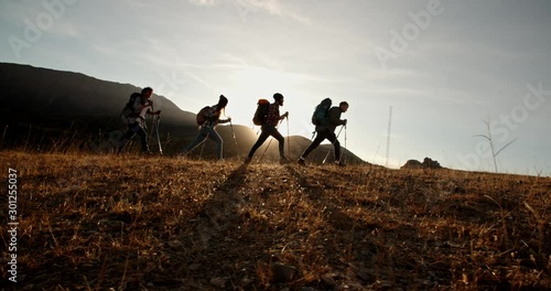 Wallpaper Mural Four young people on hike adventure - Group of students trekking in mountains together, having a vacation - friendship, travel destination concept 4k footage Torontodigital.ca