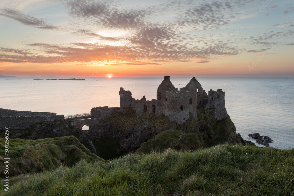 Dunluce Castle in Northern Ireland during a stunning sunset