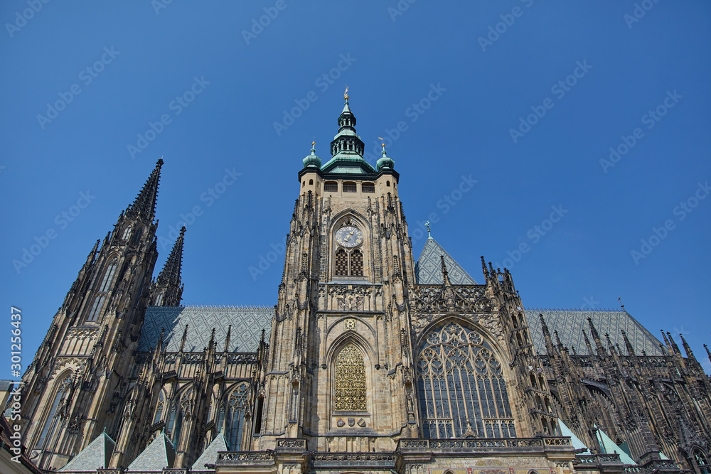 A large Gothic church with a clock against a cloudless sky in Prague, Czech Republic.