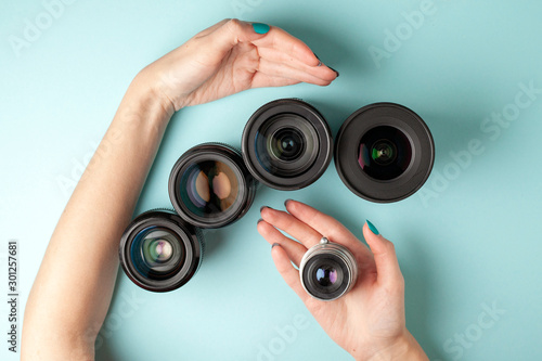 set of photo lenses on a colored background, the selection and comparison of photographic equipment, hands are holding photo equipment © Богдан Маліцький