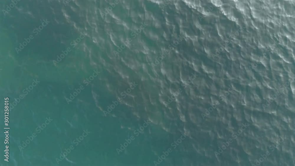 The camera shoots up. Top-down view of the sea waves. Sea ripples. Aerial view. The background of the sea. The texture of the water. Calm sea shot from above. 4K The camera shoots up. Top-down view of the sea waves. Sea ripples. Aerial view. The background of the sea. The texture of the water. Calm sea shot from above. 4K