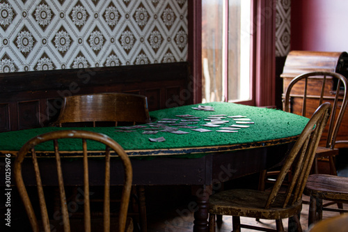 Old vintage poker cards room. green table with cards and bottles 