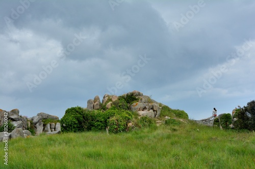 Wallpaper Mural Une femme seule qui est assise sur un rocher regarde la mer en Bretagne Torontodigital.ca