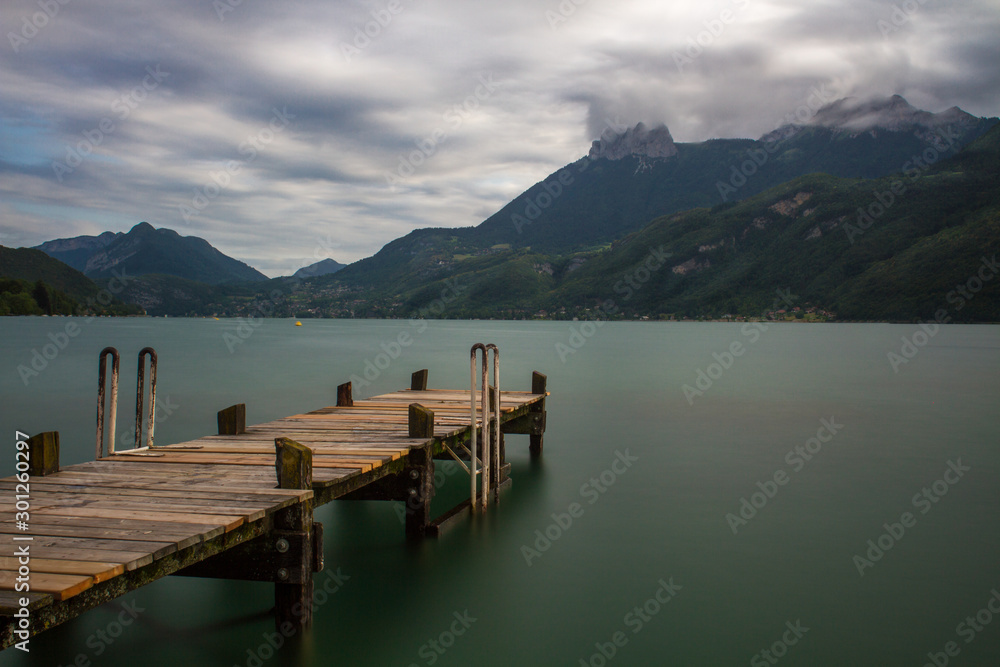 long exposure of a pier at lake annecy with dramatic clouds in the sky long exposure of a pier at lake annecy with dramatic clouds in the sky
