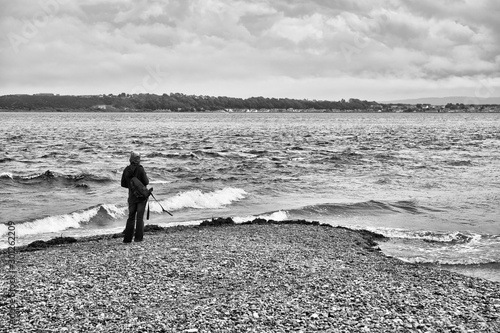 Woman with a camera watching for dolphins at Chanonry Point in the Highlands