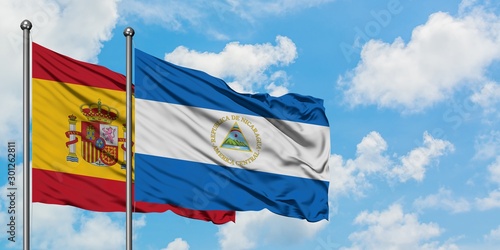 Spain and Nicaragua flag waving in the wind against white cloudy blue sky together. Diplomacy concept  international relations.