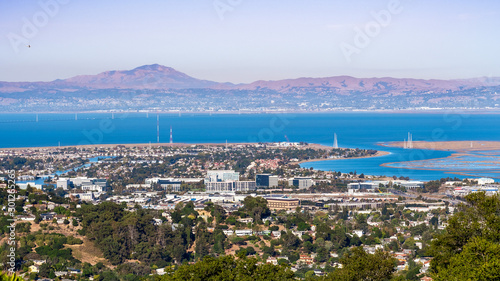 Aerial view of San Carlos and Redwood Shores; East Bay and Mount Diablo in the background; houses visible on the hills and close to the shoreline; office buildings built close to downtown San Carlos photo