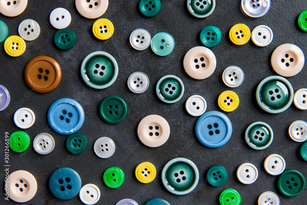 Colorful mixed sewing buttons on black background, flat lay. Top view. Colorful mixed sewing buttons on black background, flat lay. Top view.