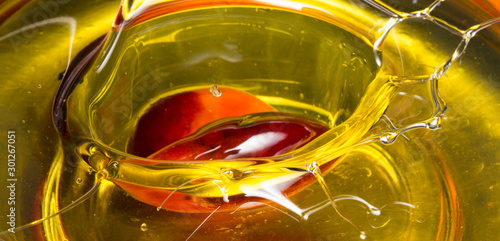 Photos Red Palm seed dropped in cooking palm oil with a splash in glass