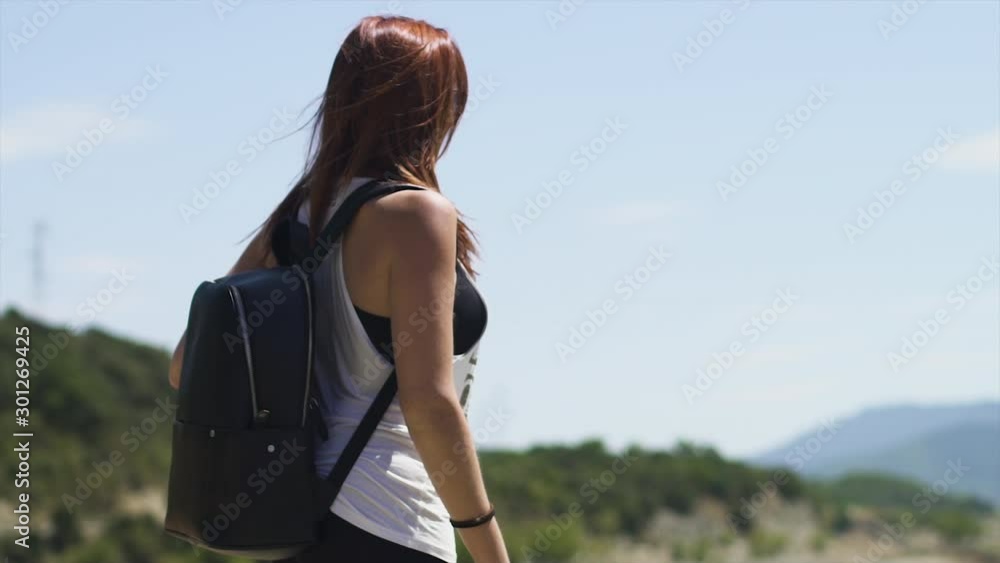 Cute explorer girl standing, hiking at beautiful blue turquoise lake of Yesa, black backpack, with rocks and green forest background during sunny summer in Spain. 4K UHD. Slow motion Medium Shot. Cute explorer girl standing, hiking at beautiful blue turquoise lake of Yesa, black backpack, with rocks and green forest background during sunny summer in Spain. 4K UHD. Slow motion Medium Shot.