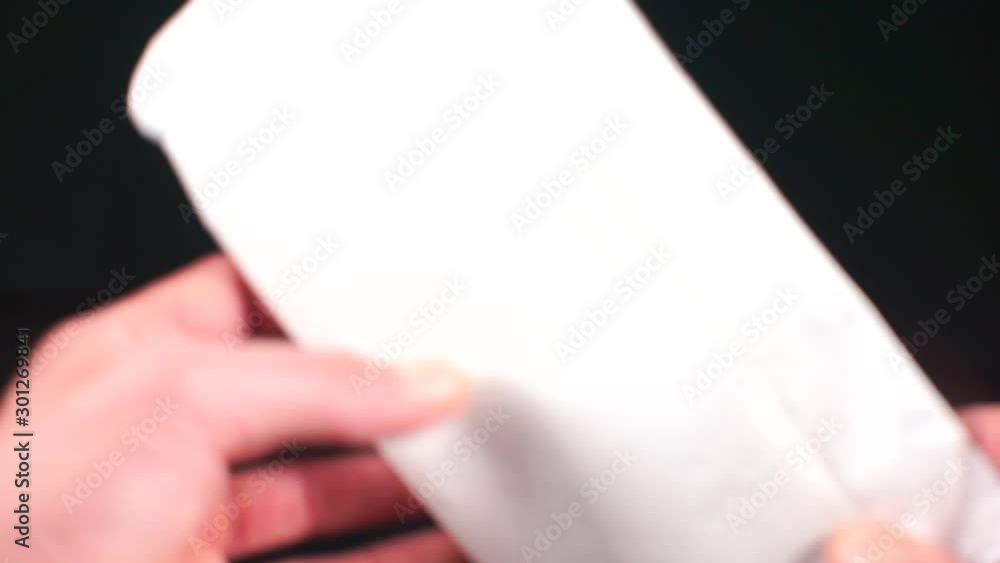 A man shifts a white envelope from hand to hand. A man shifts a white envelope from hand to hand.