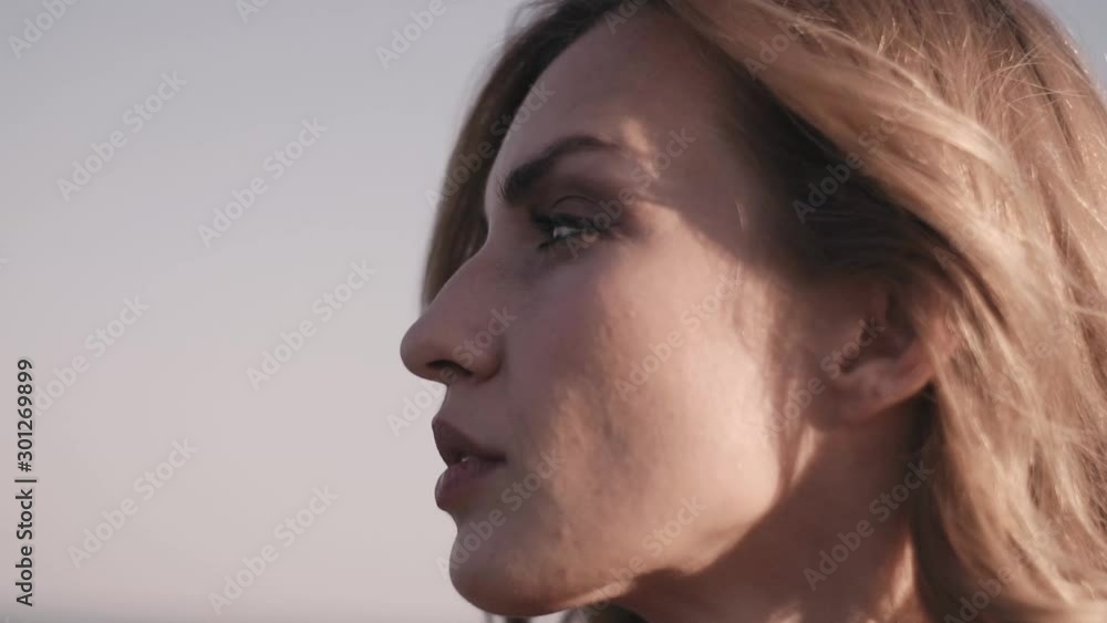 Close up of woman's face at sunset on the beach, beautiful eyes, portrait, outdoor relax sunlight, slow motion. Close up of woman's face at sunset on the beach, beautiful eyes, portrait, outdoor relax sunlight, slow motion.