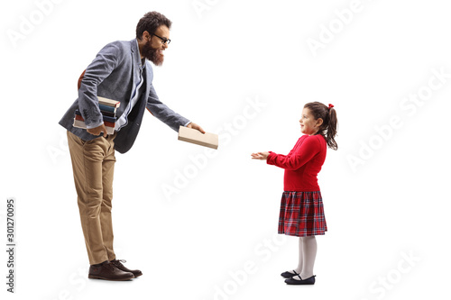Teacher giving a book to a little girl