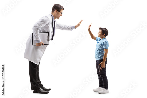 Male doctor giving a high-five to a little boy
