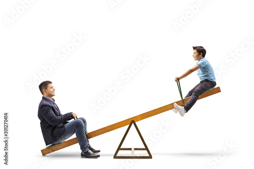 Obraz na plátne Father and son playing on a seesaw