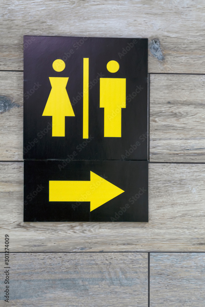 Sign with arrow pointing direction to male and female restrooms. Sign with arrow pointing direction to male and female restrooms.