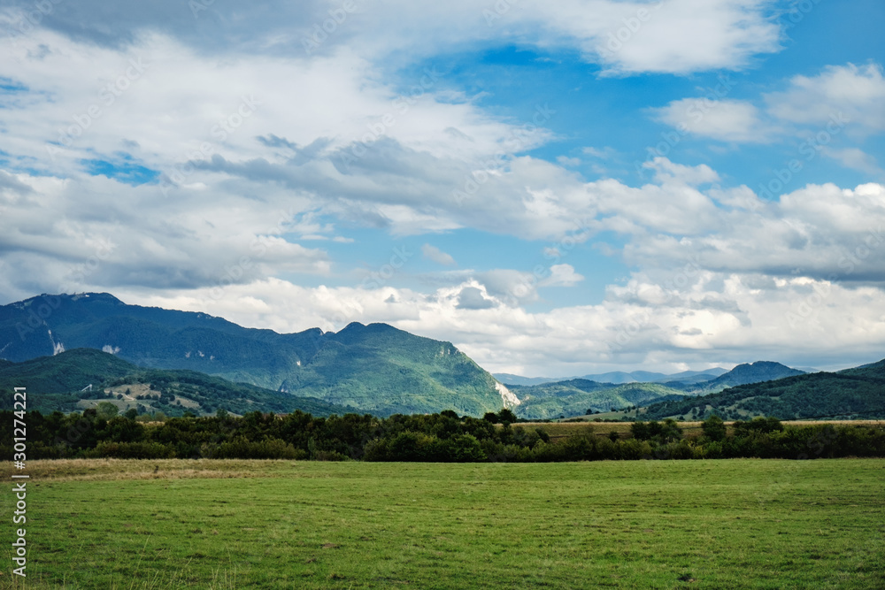A typical natural landscape in the country of Suceava: green fields and mountains on the horizon, Romania.