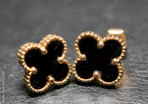 Small black clover earrings on white background. - Image