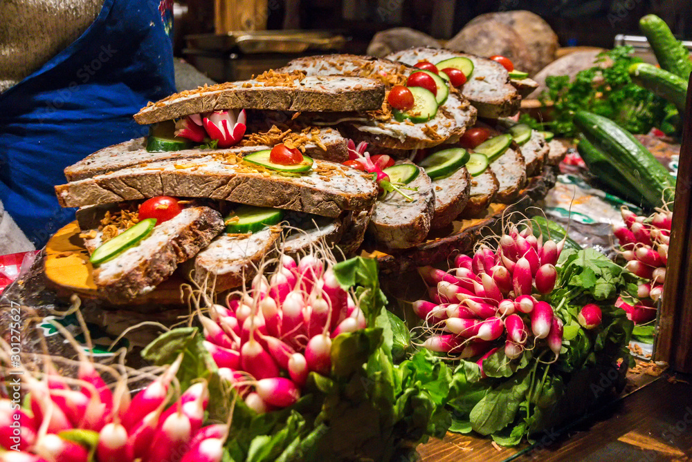 Kiosk on Christmas market with traditional German sandwiches from dark farmhouse bread, Griebenschmalz (spread from pork fat, cracklings and fried onions) and seasoned with radish