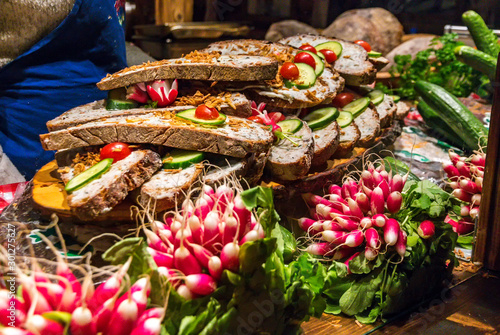 Obraz na płótnie Kiosk on Christmas market with traditional German sandwiches from dark farmhouse bread, Griebenschmalz (spread from pork fat, cracklings and fried onions) and seasoned with radish w salonie