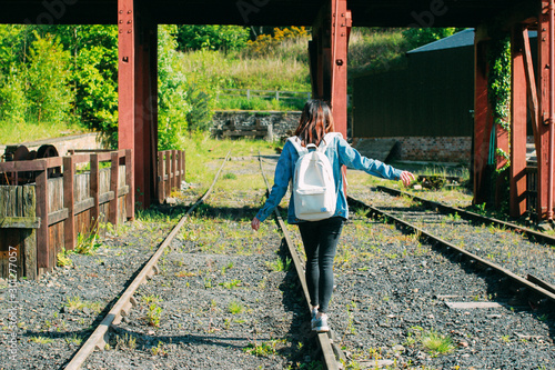 Woman walking down the train tracks