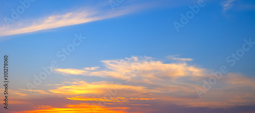 Amazing sunset panorama in a beautiful summer evening.Panorama Sky blue and orange light of the sun through the clouds in the sky.Warm light.Very beautiful sky background. selection focus.