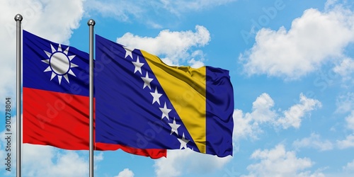 Taiwan and Bosnia Herzegovina flag waving in the wind against white cloudy blue sky together. Diplomacy concept, international relations.