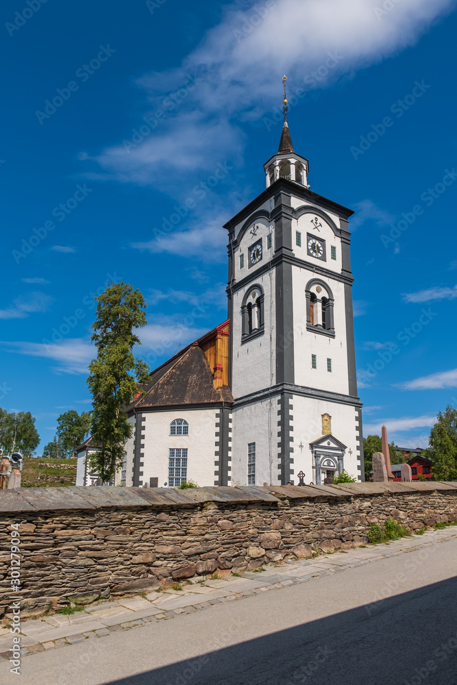 Traditional houses and church bell tower exterior of the copper mines town of Roros, Norway. Roros is declared a UNESCO World Heritage site. Traditional houses and church bell tower exterior of the copper mines town of Roros, Norway. Roros is declared a UNESCO World Heritage site.