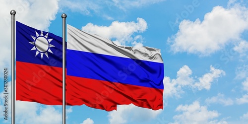 Taiwan and Russia flag waving in the wind against white cloudy blue sky together. Diplomacy concept, international relations.