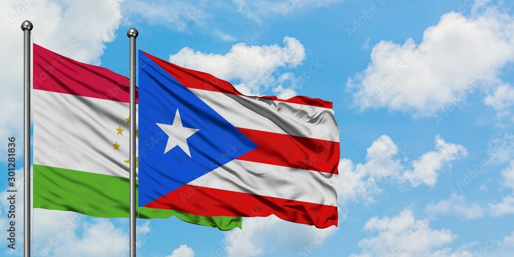 Tajikistan and Puerto Rico flag waving in the wind against white cloudy blue sky together. Diplomacy concept, international relations.