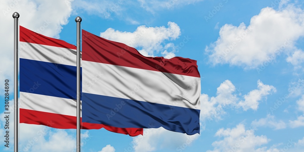 Thailand and Netherlands flag waving in the wind against white cloudy blue sky together. Diplomacy concept, international relations.