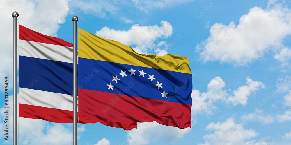 Thailand and Venezuela flag waving in the wind against white cloudy blue sky together. Diplomacy concept, international relations. Thailand and Venezuela flag waving in the wind against white cloudy blue sky together. Diplomacy concept, international relations.