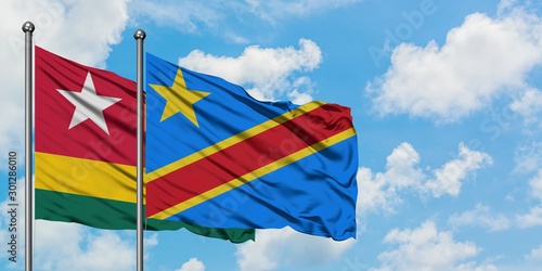 Togo and Congo flag waving in the wind against white cloudy blue sky together. Diplomacy concept, international relations.