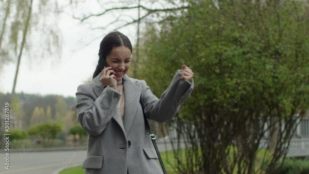 Lucky young brunette girl talks on the phone and get good news. Woman rejoices and laughs, “YES” hand sign. 4K Lucky young brunette girl talks on the phone and get good news. Woman rejoices and laughs, “YES” hand sign. 4K