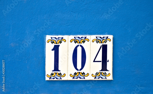Number 104, one hundred and four, decorative digits on a blue background.