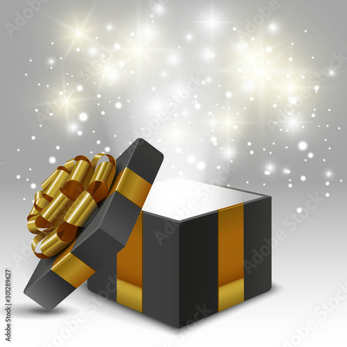 Opened gift box with gold bow and lights