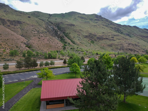 Fotografie Remarkable Aerial Photography of Beebe Bridge Park with a clear blue sky and bright cumulus clouds in a craggy mountain setting with the Columbia River outside Chelan Washington