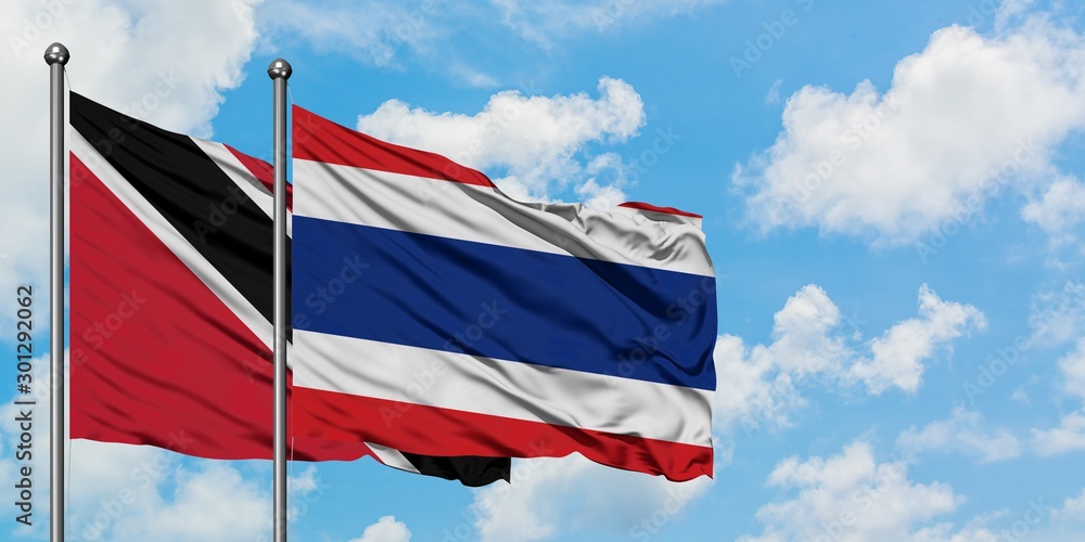 Trinidad And Tobago and Thailand flag waving in the wind against white cloudy blue sky together. Diplomacy concept, international relations.