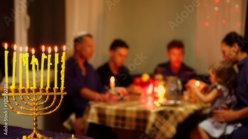 Jewish family eating together festive kosher meals. Hanukkah night. Jewish Holidays and Food. Dinner table