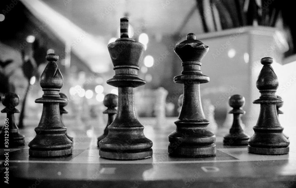 Wooden chess close up king and queen on a chess board. Black and white photo Wooden chess close up king and queen on a chess board. Black and white photo