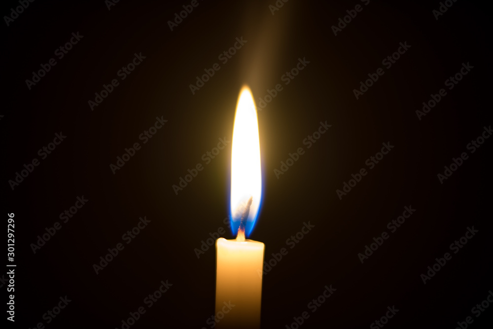One candle light illuminated in a black background. One candle light illuminated in a black background.