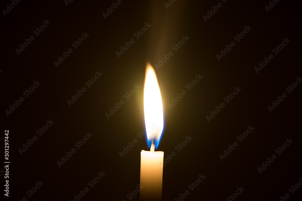 One candle light illuminated in a black background. One candle light illuminated in a black background.