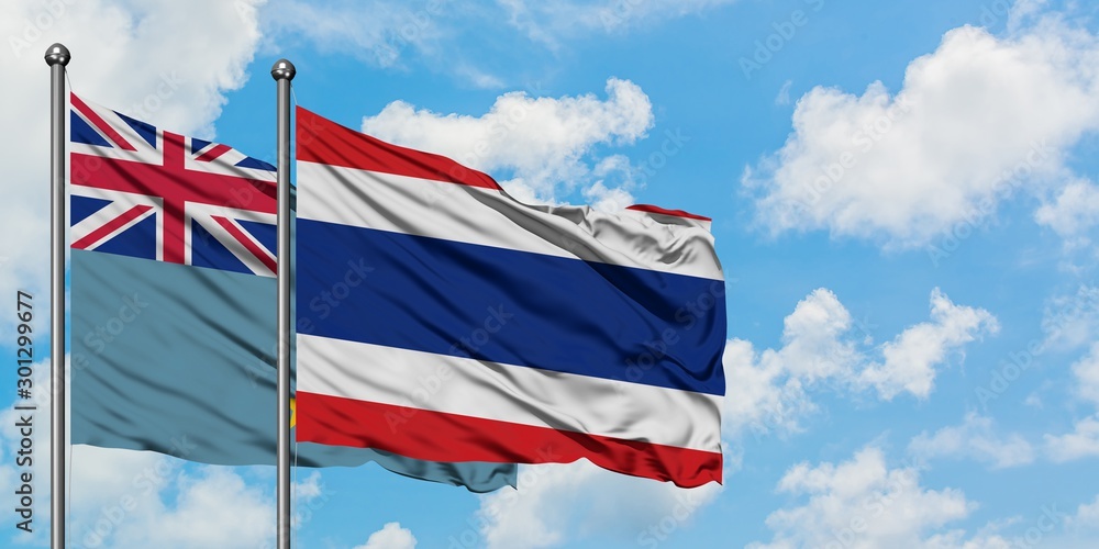 Tuvalu and Thailand flag waving in the wind against white cloudy blue sky together. Diplomacy concept, international relations.