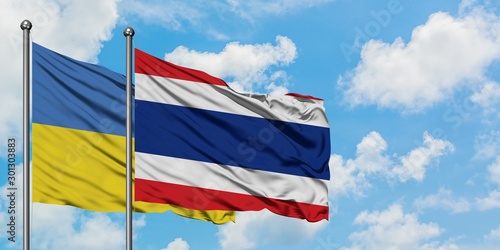 Ukraine and Thailand flag waving in the wind against white cloudy blue sky together. Diplomacy concept, international relations.