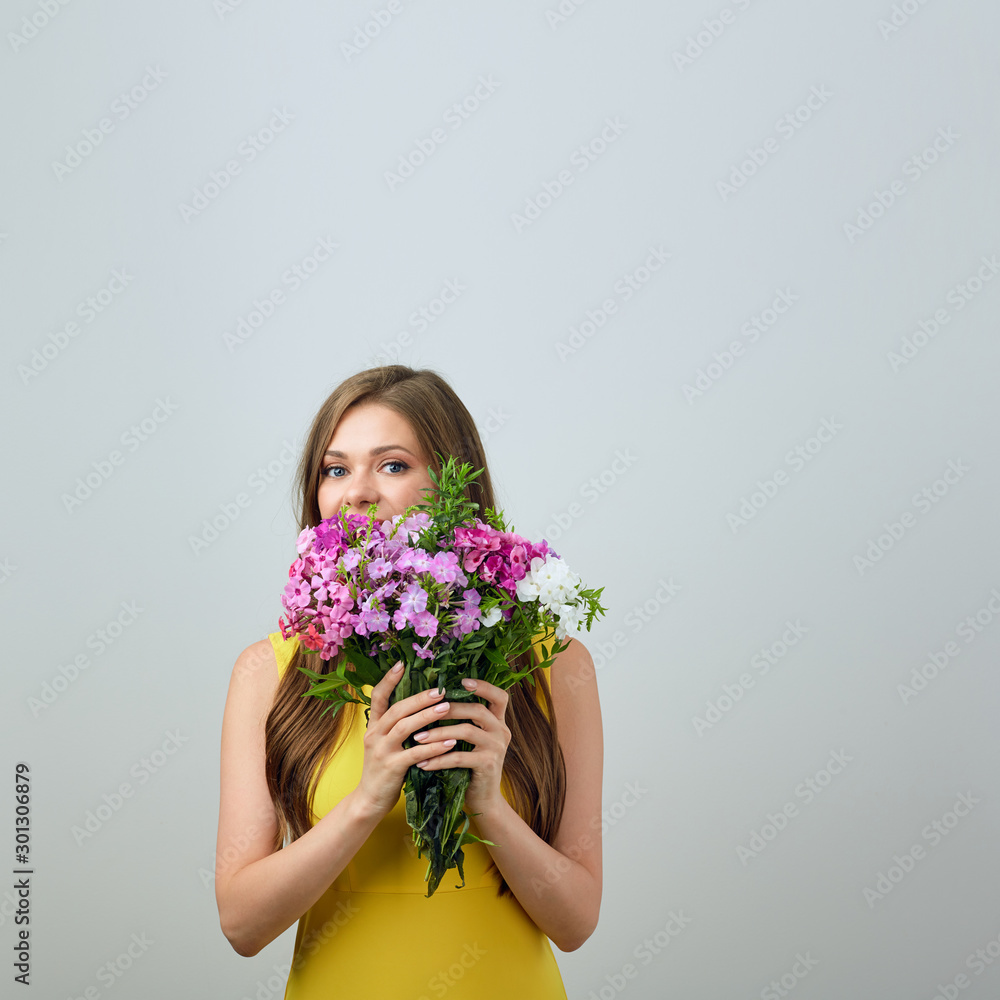 woman holding flowers in front of face.