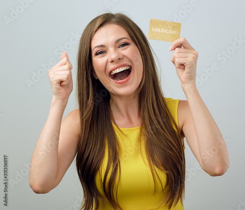 Happy emotional young woman holding credit card. photo