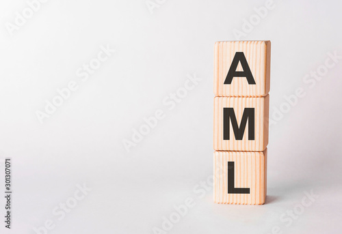 AML letters of wooden blocks in pillar form on white background, copy space