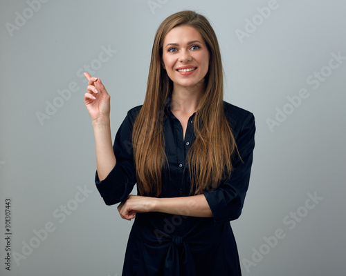 woman in black dress pointing with one finger to copy space.