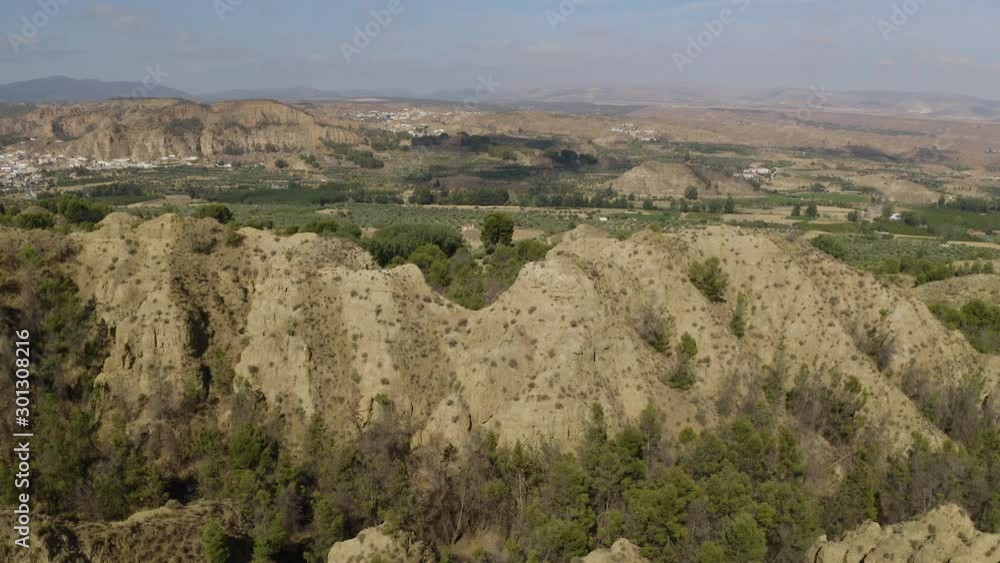 Aerial Drone view of dry valley and mountains at Mirador del fin del mundo in Blue sky, Sierra Nevada, Granada, Spain. Spanish desert canyon with vegetation, in Andalusia. Fast moving upward tilt. Aerial Drone view of dry valley and mountains at Mirador del fin del mundo in Blue sky, Sierra Nevada, Granada, Spain. Spanish desert canyon with vegetation, in Andalusia. Fast moving upward tilt.